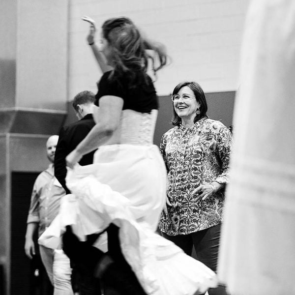 A black and white image of Lindy Hume, Artistic director of Ten Days' watching dancers dance